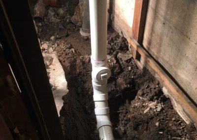 Newly put together PVC piping to create the new waste stack. Front angle.