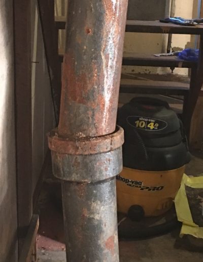 The connection between two cast iron pipes have created a bend.